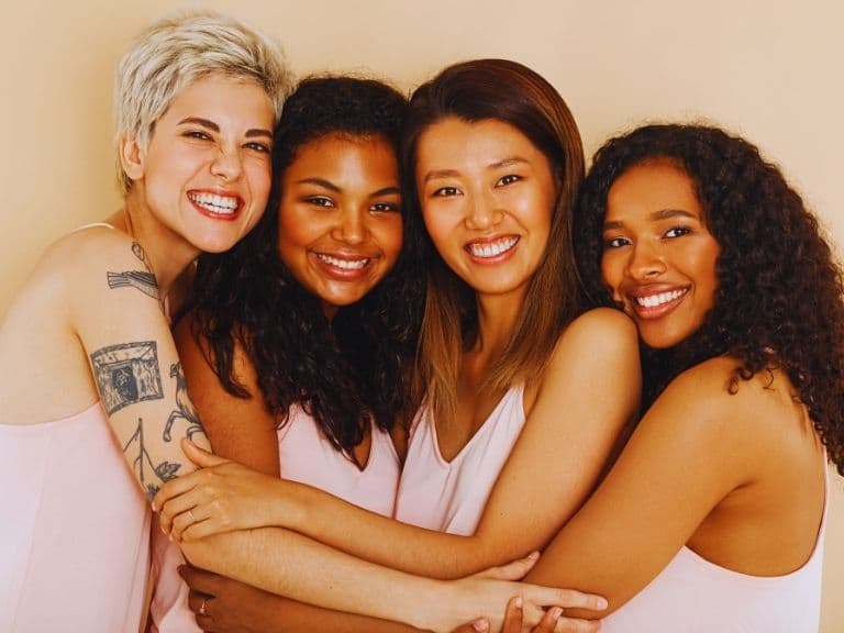 A diverse group of women standing united, representing the strength found in forgiveness, mutual support, and the positive impact of a community encouraging growth.